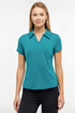 A woman modeling a short-sleeve collared athletic top in teal blue, paired with black pants, against a plain white studio background. 
