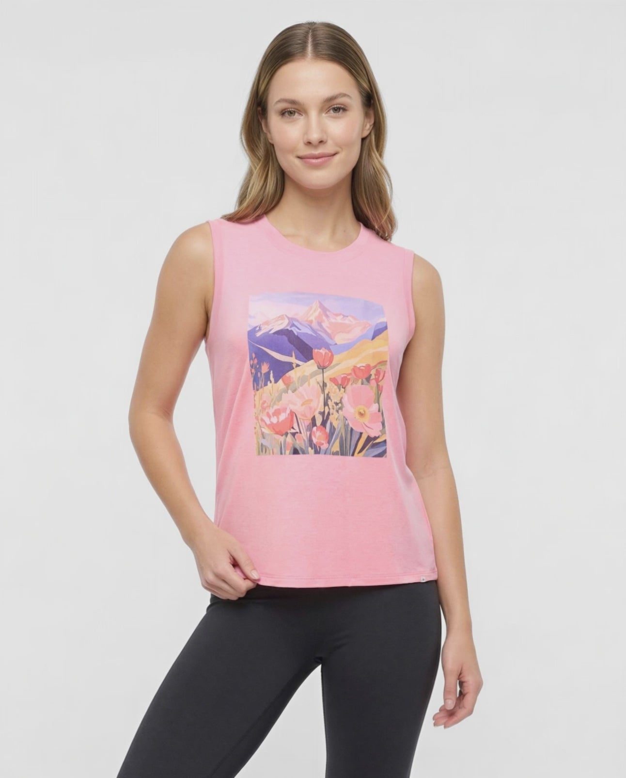 Video view of woman wearing a pink sleeveless top with a colorful floral and mountain design on a white background. #color_heather-rosy-future-vibrant-fields