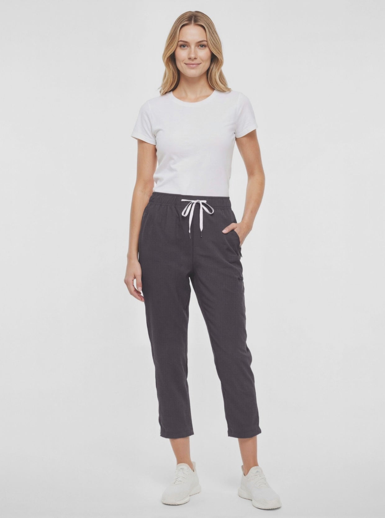Video view of woman wearing black cropped pants with a white drawstring on a white background. 
