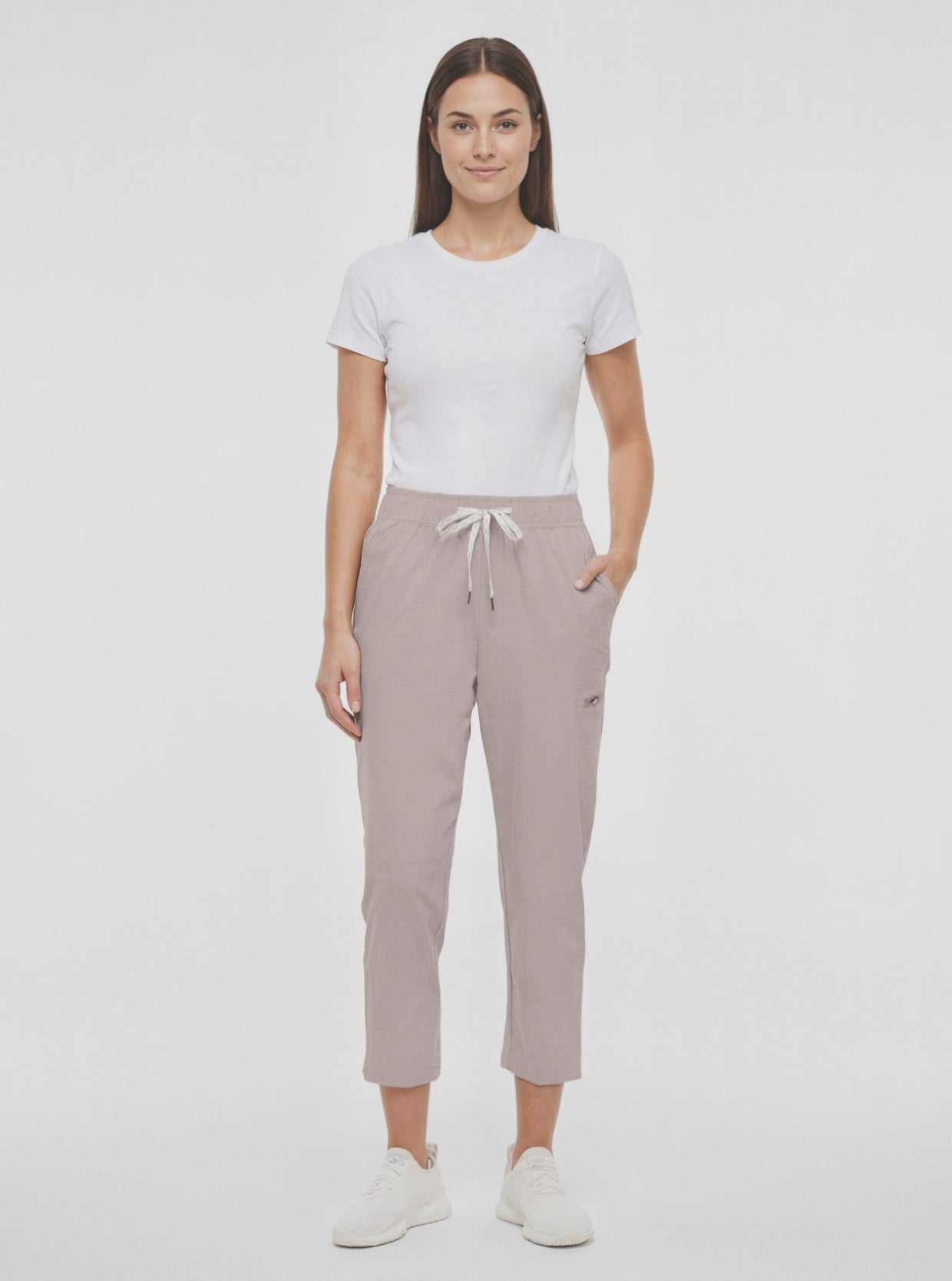 Video view of beige pants worn by a woman with white drawstring waist on a white background. 