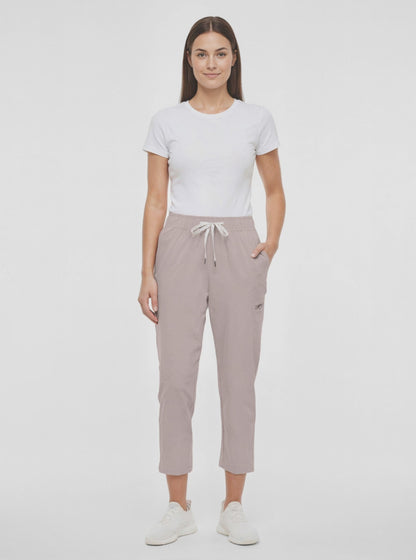 Video view of beige pants worn by a woman with white drawstring waist on a white background. 