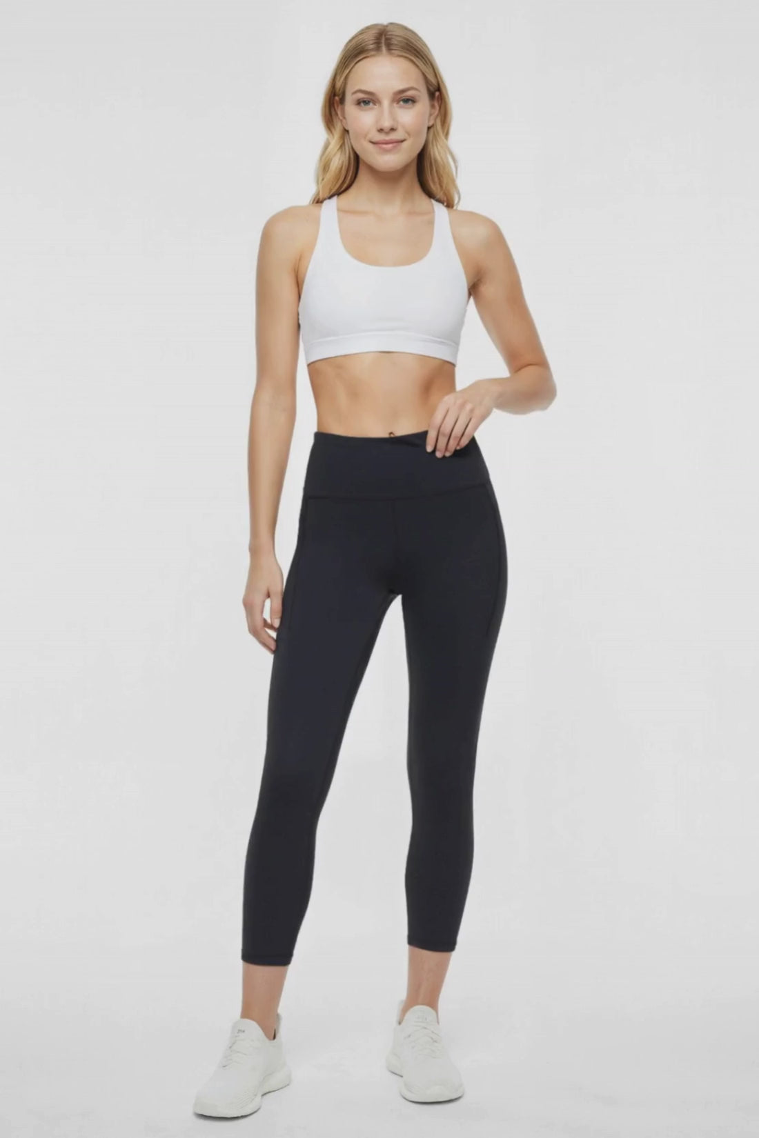 Video view of woman wearing black leggings worn by a person on a white background. #color_black
