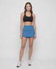 Video of woman wearing a blue skort with waist clasp and white sneakers on a white background. #color_midnight