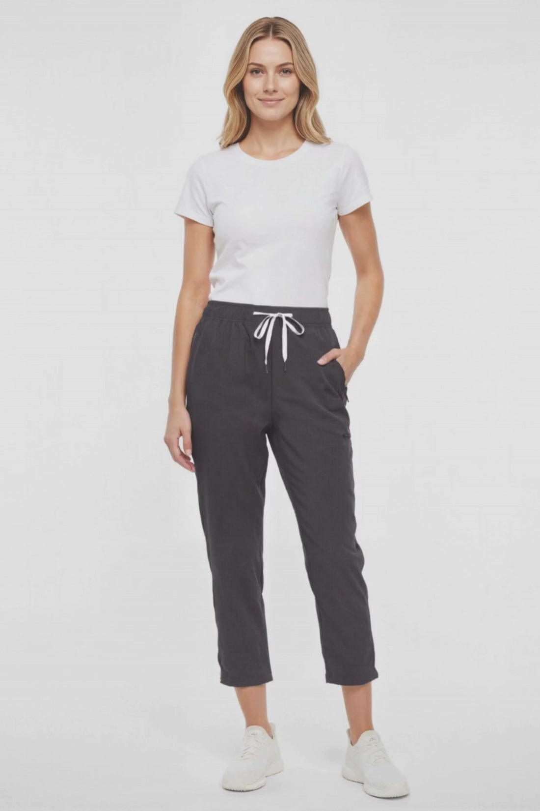 Video  view of woman wearing black cropped pants with a white drawstring on a white background. 