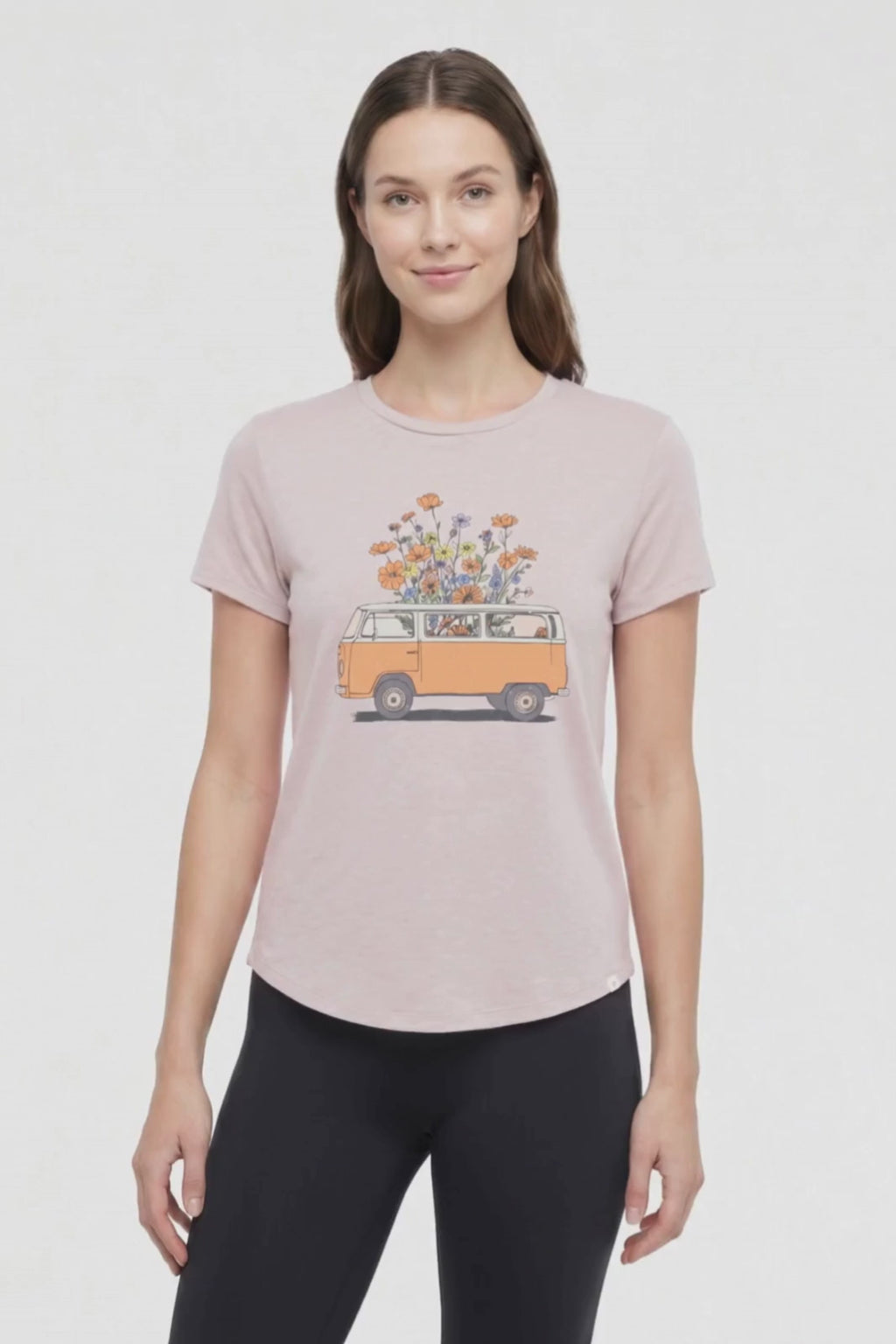 Video view of woman wearing a beige t-shirt with a graphic of an orange van and flowers on a .white background. #color_heather-atmosphere-floral-van-life