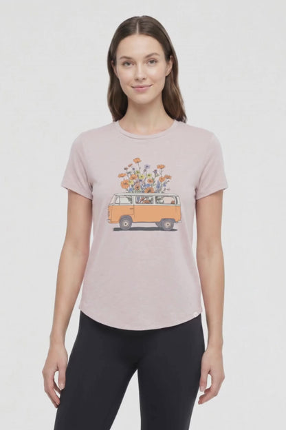 Video view of woman wearing a beige t-shirt with a graphic of an orange van and flowers on a .white background. 