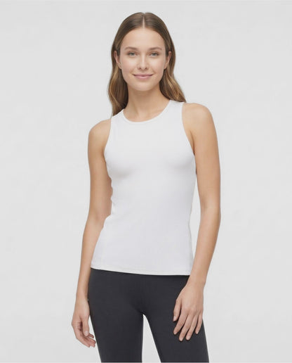 VIDEO View of woman wearing a white sleeveless top and black leggings on a light gray background. 