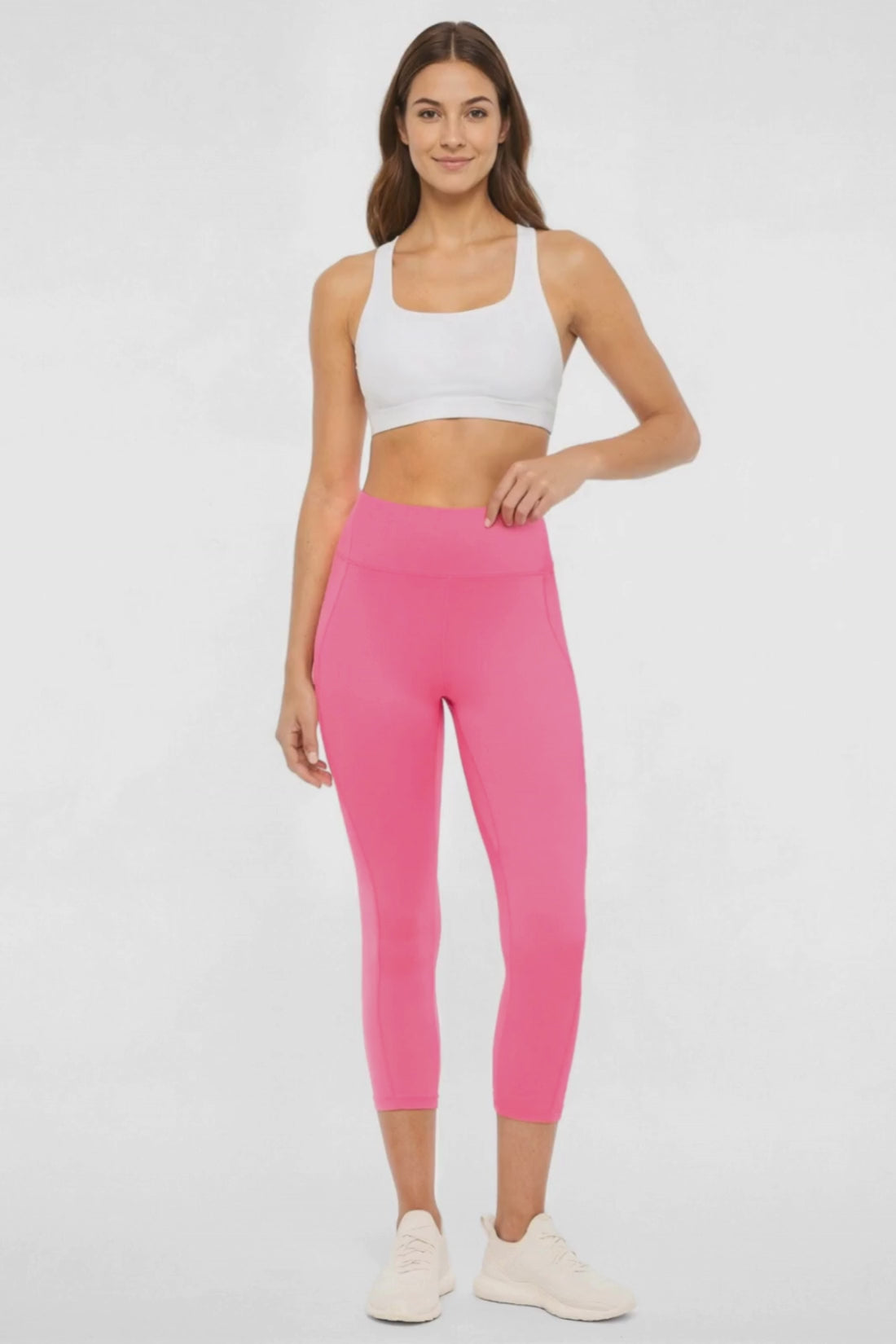 Video view of woman wearing pink capris and white sneakers on a light gray background. #color_pink-flambe