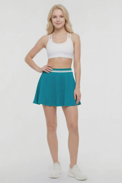 Video view of teal skirt with white stripe waistband worn by a woman on a white background. 